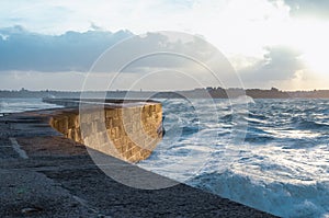 Big waves crushing on stone pier