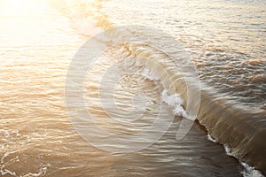 Big waves with foam on the pebbly beach On the Sunset