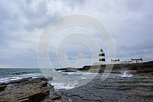 Big waves hitting stones at hook lighthouse. Wexford, Ireland