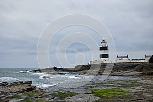 Big waves hitting stones at hook lighthouse. Wexford, Ireland