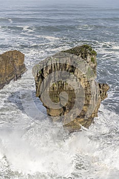 Big waves smashing on worn cliff at Tasman sea shore, Punakaiki, West Coast, New Zealand