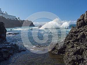 Big waves splash against natural rock swimming pool Charco de Isla Cangrejo in the Atlantic Ocean in Los Gigantes, Tenerife, photo