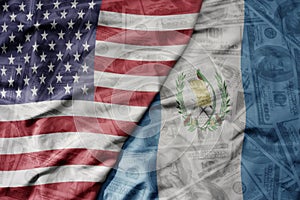 big waving colorful flag of united states of america and national flag of guatemala on the dollar money background. finance