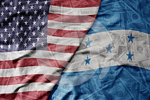 big waving colorful flag of united states of america and national flag of honduras on the dollar money background. finance concept