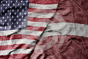 big waving colorful flag of united states of america and national flag of latvia on the dollar money background. finance concept