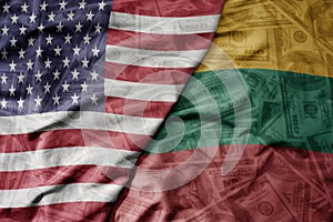 big waving colorful flag of united states of america and national flag of lithuania on the dollar money background. finance