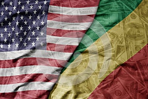 big waving colorful flag of united states of america and national flag of republic of the congo on the dollar money background.