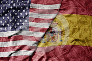 big waving colorful flag of united states of america and national flag of spain on the dollar money background. finance concept