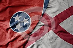 big waving colorful national flag of alabama state and flag of tennessee state