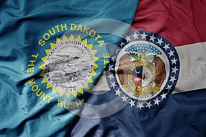 big waving colorful national flag of missouri state and flag of south dakota state