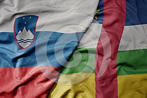 big waving national colorful flag of central african republic and national flag of slovenia