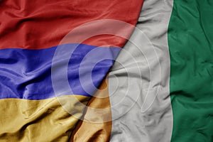 big waving national colorful flag of cote divoire and national flag of armenia