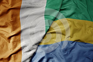 big waving national colorful flag of cote divoire and national flag of gabon