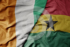 big waving national colorful flag of cote divoire and national flag of ghana