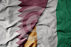 big waving national colorful flag of cote divoire and national flag of qatar