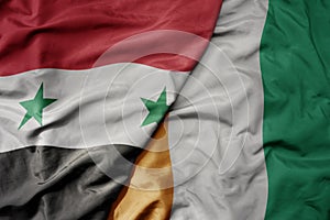 big waving national colorful flag of cote divoire and national flag of syria