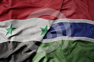 big waving national colorful flag of gambia and national flag of syria