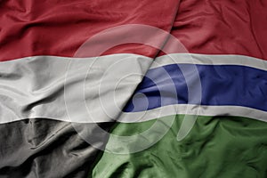 big waving national colorful flag of gambia and national flag of yemen