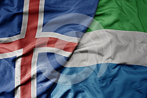 big waving national colorful flag of icelandic and national flag of sierra leone