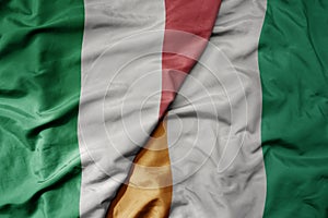 big waving national colorful flag of italy and national flag of cote divoire