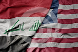 big waving national colorful flag of liberia and national flag of iraq