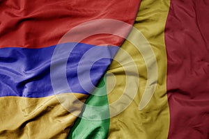 big waving national colorful flag of mali and national flag of armenia