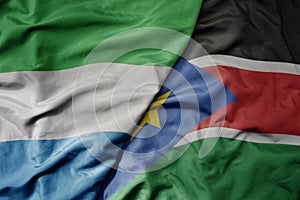 big waving national colorful flag of sierra leone and national flag of south sudan