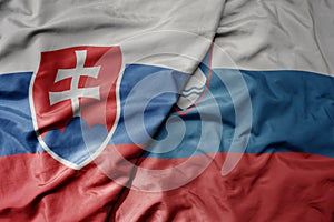 Big waving national colorful flag of slovakia and national flag of slovenia
