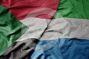 big waving national colorful flag of sudan and national flag of sierra leone