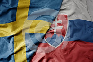 Big waving national colorful flag of sweden and national flag of slovakia