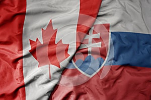 Big waving realistic national colorful flag of canada and national flag of slovakia