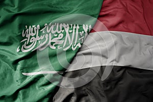 big waving realistic national colorful flag of saudi arabia and national flag of yemen