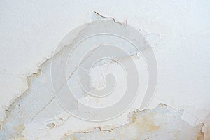 Big wet spots and cracks on the ceiling of the domestic house room after heavy rain leakage and lot of water, damaged plaster of t