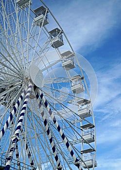 Big Wheel against blue sky with clouds.