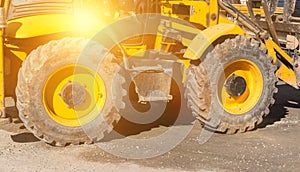 Big wheels of excavator on the ground. Heavy machinery photo background