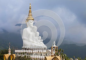 big white buddha statues sitting on valley mountain with fog in Wat Phra That Pha Son Kaew Thailand.