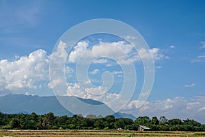 big white clouds on deep blue sunny sky in winter season with hill top in the deep forest