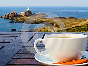 Big white cup on a table and seacoast as a background