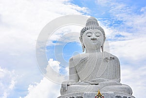 Big white marble Buddha isolated on cloudy and blue sky background, copy space, Phuket, Thailand
