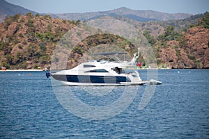 Big white modern yacht moored in Aegean sea near Turkey coast. Luxury white boat yacht against of the resort city. Ships