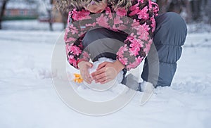 Big white snow comp. The child plays outdoors with snow in March. Snow in spring in Ukraine