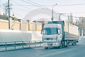 Big white truck passes through city street