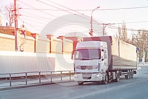 Big white truck passes through city street