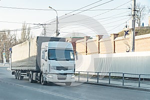 Big white truck passes through city street