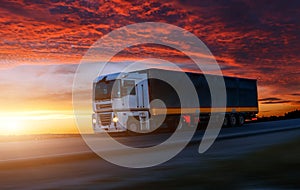 Big White Truck on the Road in a Rural Landscape at Sunset