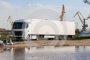 big white truck and it\'s reflection on the puddle