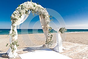 Big white wedding arch at ocean coast