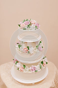 big white wedding cake with flowers on the table