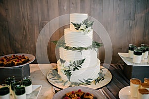 Big white wedding cake with fruit is on the table