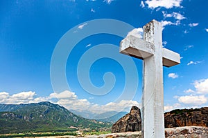 Big white wooden cross on the sky background